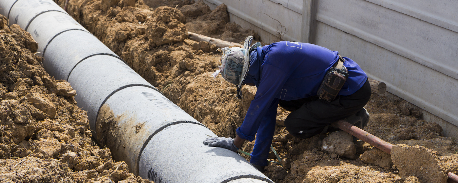 Worker install Precast concrete manholes ; for draining storm water ; outdoor working in hot weather ; construction industrial background